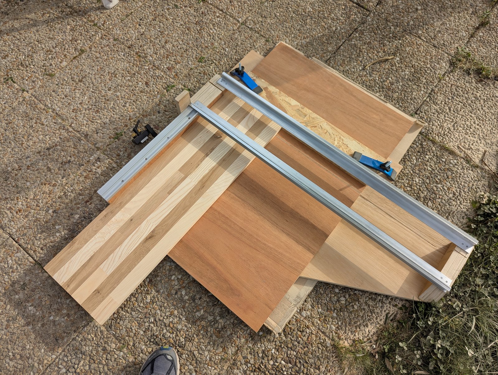 Panneau installé dehors sur des planches de support, avec un guide métallique fixé en travers.