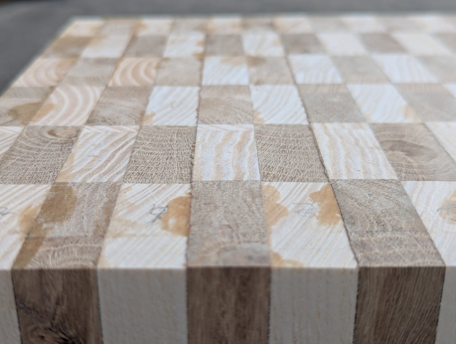 Vue rapprochée en perspective du bord de la planche et des motifs du bois sur sa surface.